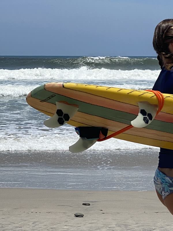 digital nomad catching a morning surf before remote work